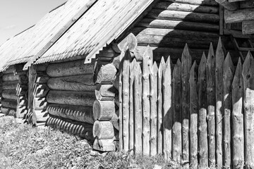 An old hut made of thick logs and a wooden palisade.