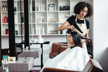 Young brunette woman enjoying professional hairstyling at beauty salon