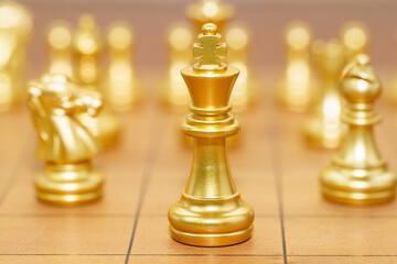 Gold king chess piece stand on wood chessboard