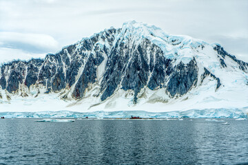 Antarctica, Antarctic Peninsula, cruising in the Lemaire Channel. Ice covered mountain and ice floes. 