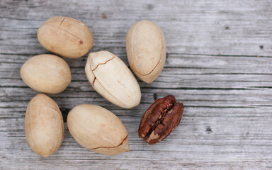 Pecan Nuts on wooden background, top view with copyspace. Close up veiw of nuts.