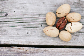 Obraz premium Pecan Nuts on wooden background, top view with copyspace. Close up veiw of nuts.