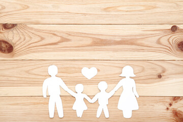 Family figures with heart on brown wooden table