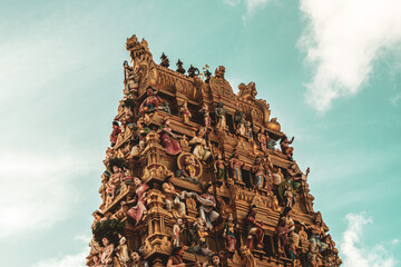 Hindu temple full of colorful ornaments against a blue sky on a sunny day.  © insomniafoto