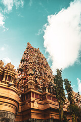 Hindu temple full of colorful ornaments against a blue sky on a sunny day.  © insomniafoto