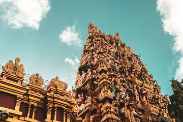 Hindu temple full of colorful ornaments against a blue sky on a sunny day.  © insomniafoto