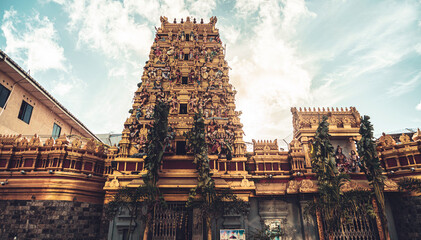 Hindu temple full of colorful ornaments against a blue sky on a sunny day.  © insomniafoto