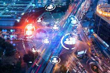 Social media icons hologram on top view of road, busy urban traffic highway at night. Junction network of transportation infrastructure. The concept of networking and success. Double exposure.