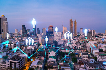 Fototapeta premium Hologram of social media icons over sunset panoramic cityscape of Bangkok, Asia. The concept of people connections. Multi exposure.