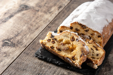 Christmas stollen fruit cake on wooden table. Copy space