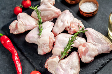 raw chicken wings with spices on a stone background