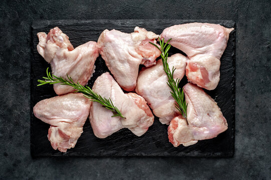 raw chicken wings with spices on a stone background