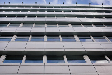 A view from below on an office building in a business district against a blue sky. Business...