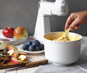 The process of making a charlotte with apples and plums.Hands of an elderly woman gently knead the dough with flour. Preparation for the holiday or for meeting guests.