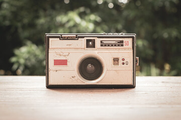 Old photo camera from the 60s on rustic wooden tab
