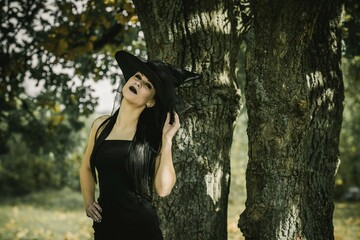 Halloween outfit for lady. Beautiful young woman in black modern dress . Halloween art design. Dark theme For Halloween Concept