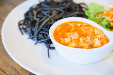 Black spaghetti with tomato chicken sauce.