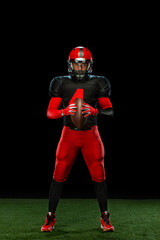 American football player, athlete sportsman in red helmet on black background. Sport and motivation wallpaper.
