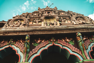 Hindu temple full of colorful ornaments against a blue sky on a sunny day.
 - obrazy, fototapety, plakaty