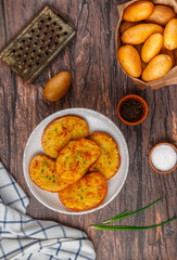 Sandwiches with fried potatoes and green onions. Delicious appetizer in a rustic style. Bread, salt, pepper and raw potato on the table. Selective focus