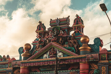 Hindu temple full of colorful ornaments against a blue sky on a sunny day.  © insomniafoto