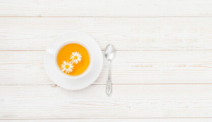 Cup of herbal tea with honey and chamomile flowers on the white wooden background flat layout