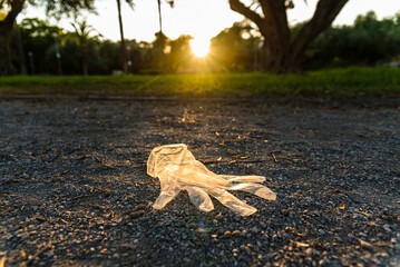 Plastic gloves from a supermarket abandoned on the ground in a park, polluting.