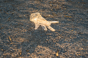 Plastic gloves from a supermarket abandoned on the ground in a park, polluting.