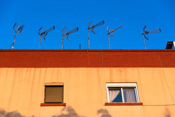 Several outdoor antennas to capture television signals on the roof of a building in Spain.