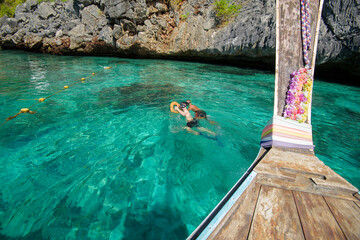 view from thai traditional longtail Boat while tourists snorkeling and diving in the ocean, Phi phi...