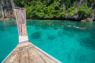 view from thai traditional longtail Boat while tourists snorkeling and diving in the ocean, Phi phi Islands, Thailand