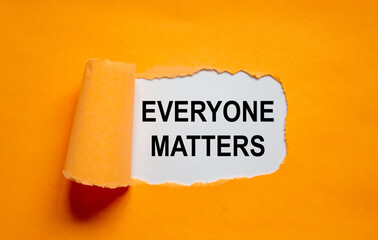 The words 'everyone matters' appearing behind torn orange paper. Beautiful background. Concept.