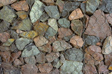Gabion, texture, background. Wall made of natural rocks and metal fences.
