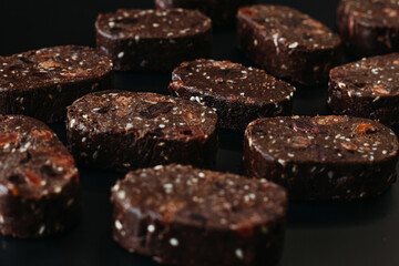 Chocolate candies on black background, close-up.
