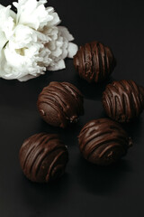 Handmade chocolates on dark background.