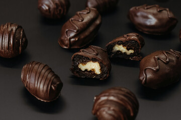 Handmade chocolates with nut inside on dark background.
