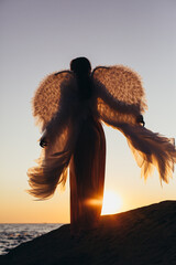 Girl with angel wings at sunrise sun. - 376736528