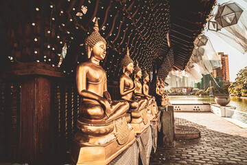 Golden Buddha statues in a Buddhist temple. - obrazy, fototapety, plakaty