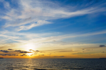 Fototapeta premium Sunset over the sea. Reflection of sunlight in the sea waves. The sky in the sunset rays.