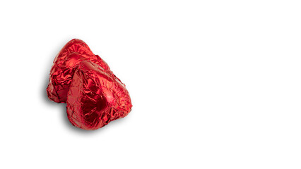 Sweet chocolate heart shaped candy wrapped in red foil papper on white background. High quality photo