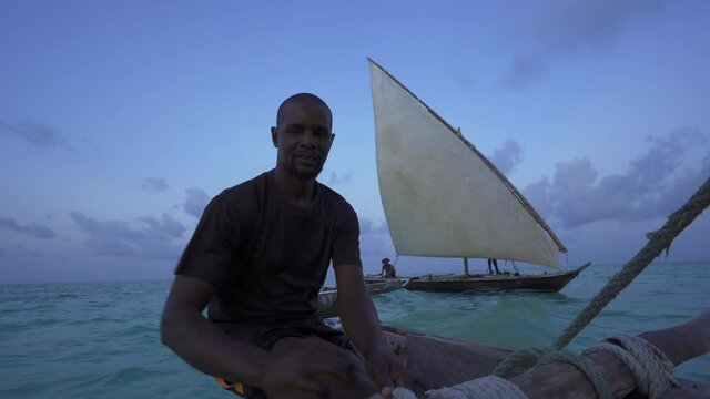 Outrigger sailing dhow travelling off the coast of Zanzibar. Tanzania. Africa.