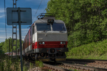 Naklejka premium Red fast passenger train on main railway in Slovakia near Vysoke Tatry mountains