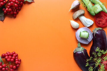 Eggplant, tomatoes, mushrooms, onions, garlic, viburnum branches on a yellow background, top view, space for text