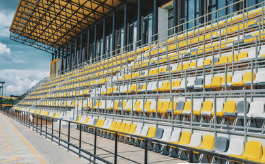 Yellow and gray chairs on sports podium for spectators