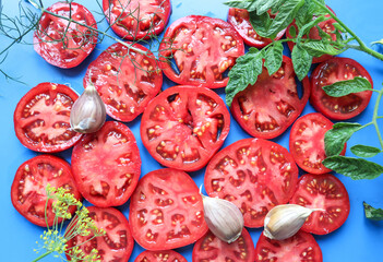 Background of fresh red sliced tomatoes with garlic, top view, close-up
