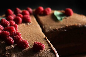 Prague cake. Chocolate cake with raspberries. Cake on a dark background.