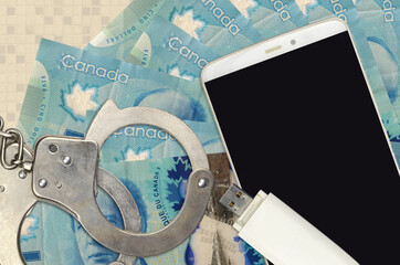 5 Canadian dollars bills and smartphone with police handcuffs. Concept of hackers phishing attacks,...