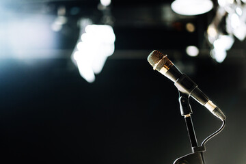 The microphone connected with cable on abstract blurred of light in the studio, speaking conference...