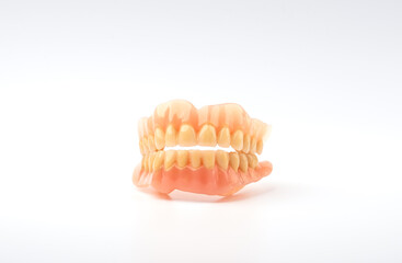plastic full removable denture of human teeth closeup isolate on white background