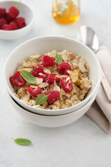 Oatmeal with raspberries, honey and almond petals. Healthy breakfast.